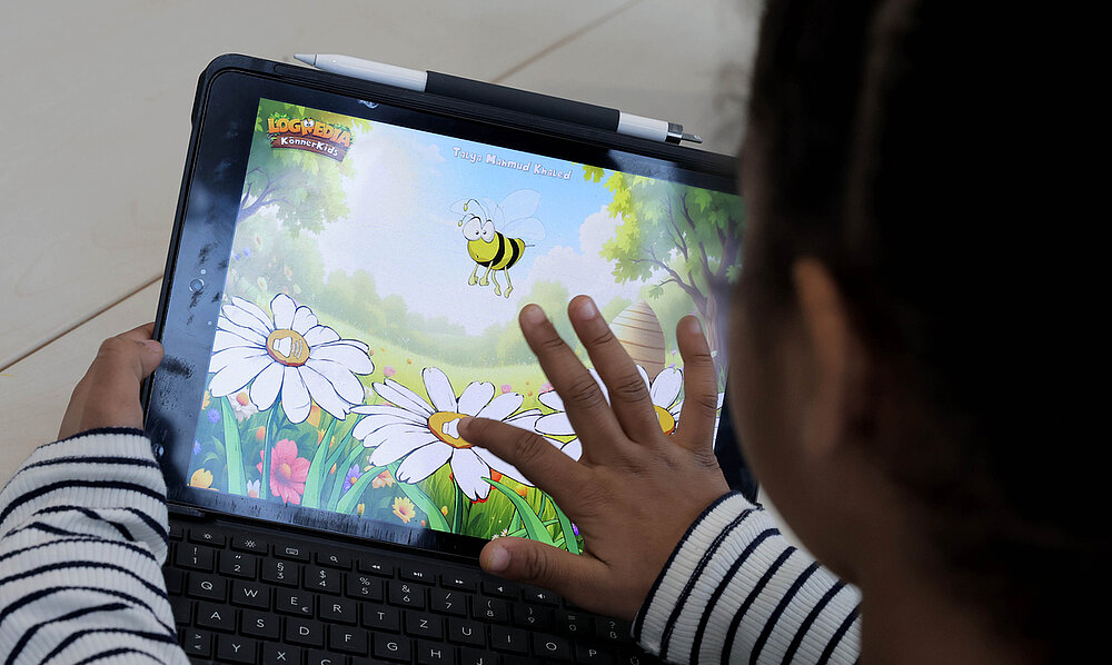 Kind bearbeitet ein digitales Screening-Verfahren am Tablet